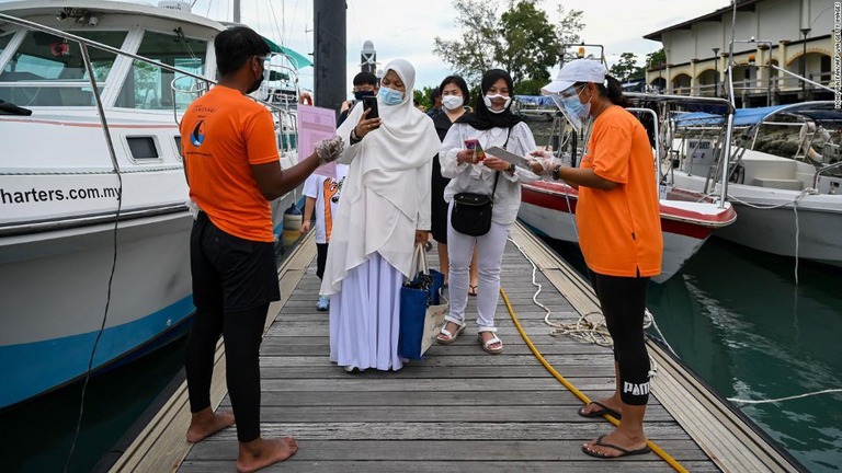 ヨットの乗客が乗船前に健康状態を監視するアプリを利用＝１７日、マレーシア・ランカウイ/MOHD RASFAN/AFP via Getty Images