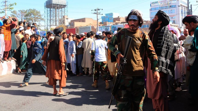 タリバンが拉致事件の犯人とされる男性の遺体をつり下げた広場に集まった人々＝アフガニスタン西部ヘラート州/AP