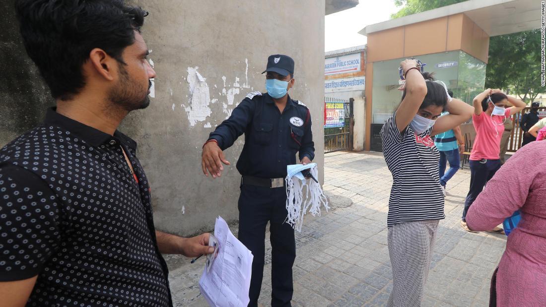 新しい使い捨てのマスクを受け取る受験者＝２６日、インド・ラジャスタン州の試験会場/Vishal Bhatnagar/NurPhoto/Getty Images