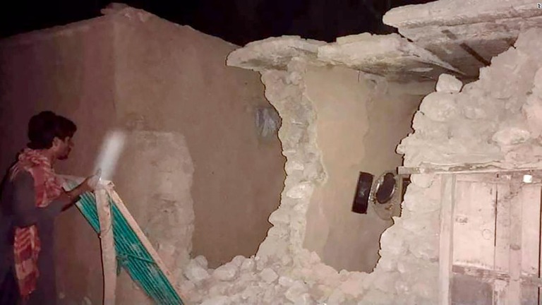 地震で破損した家屋の状態を調べる住民/AP 