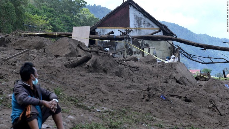 土砂崩れの被害にあった家屋の近くに座る住民＝１６日、インドネシア・バリ島/DIMAS DHANI/AFP/AFP via Getty Images