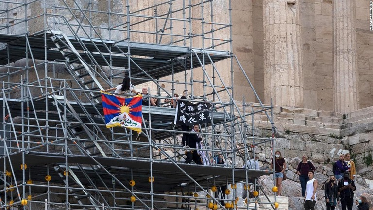 １７日、アクロポリスの遺跡でチベットの旗などを掲げる活動家/Yorgos Karahlis/AP