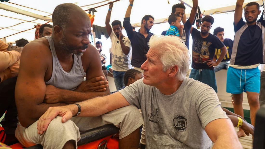 救助艇に乗っている難民の男性と話すリチャード・ギアさん(右)=2019年8月、地中海/Valerio Nicolosi/AP