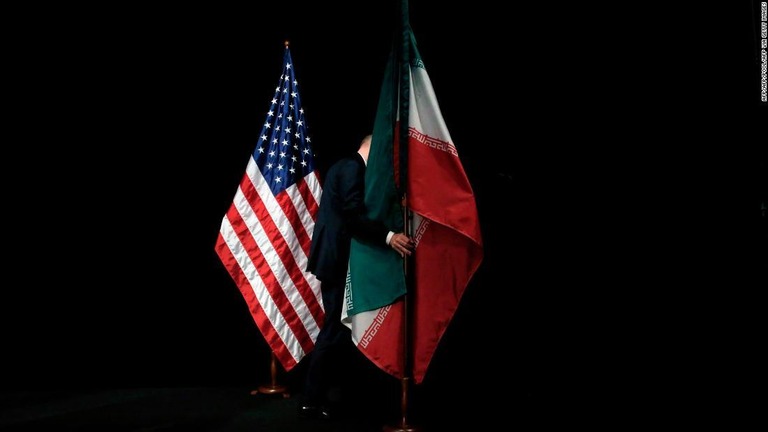 米国とイランの国旗。２０１５年のイランと米国など６カ国の協議後にスタッフが旗を撤収する様子/AFP/AFP/POOL/AFP via Getty Images