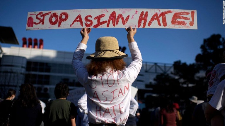 憎悪犯罪への抗議デモでアジア人に対する犯罪を止めるようプラカードで呼び掛ける女性/MARK FELIX/AFP/Getty Images