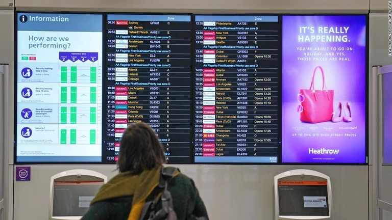 英ロンドンのヒースロー空港で出発便の案内板を確認する旅行者/Steve Parsons/PA Images/Getty Images