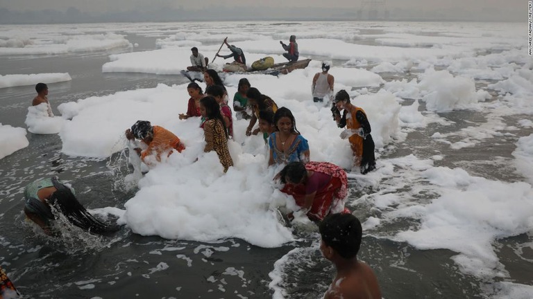 白い泡が浮かぶヤムナ側に入り、沐浴する首都ニューデリーの住民/Anushree Fadnavis/Reuters