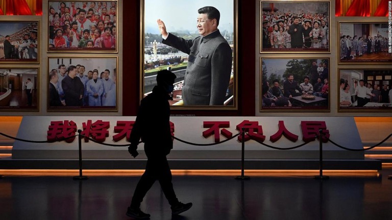 北京の中国共産党歴史展覧館に展示された習近平国家主席の写真の前を歩く男性/NOEL CELIS/AFP/AFP via Getty Images