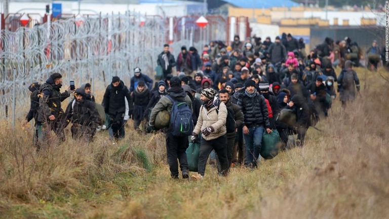 ベラルーシとポーランドの国境付近のベラルーシ側を歩く移民の集団＝１２日/Leonid Shcheglov/Belta/AFP/Getty Images