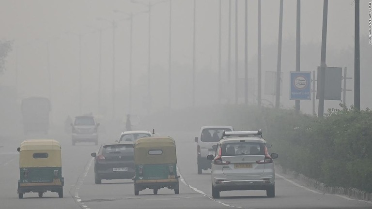 視界が悪い中走る車＝１１月７日、ニューデリー/Money Sharma/AFP/Getty Images