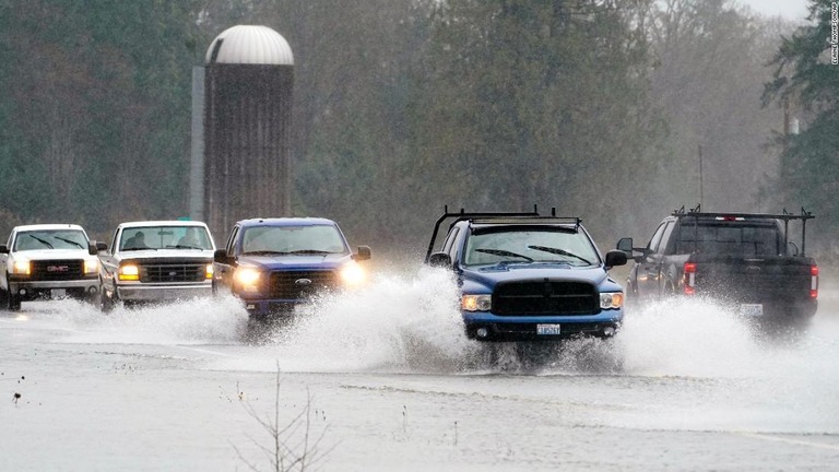 ワシントン州ハミルトン付近で冠水状態のハイウェー２０号を車が走る/Elaine Thompson/AP