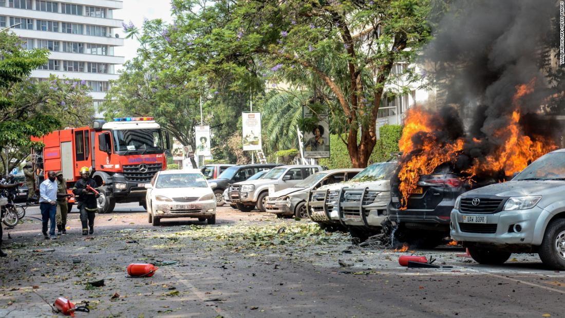 爆発による火災の消火活動にあたる人々＝１６日、ウガンダ・カンパラ/Ivan Kabuye/AFP/Getty Images