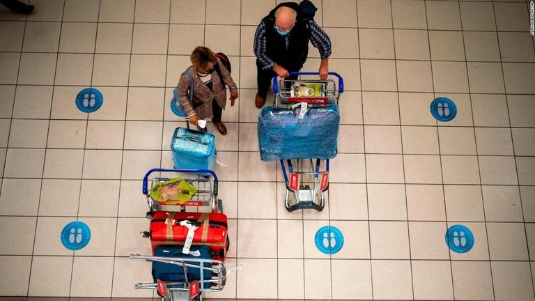 空港で便を待つ旅行者＝２６日、南アフリカ・ヨハネスブルク/Jerome Delay/AP