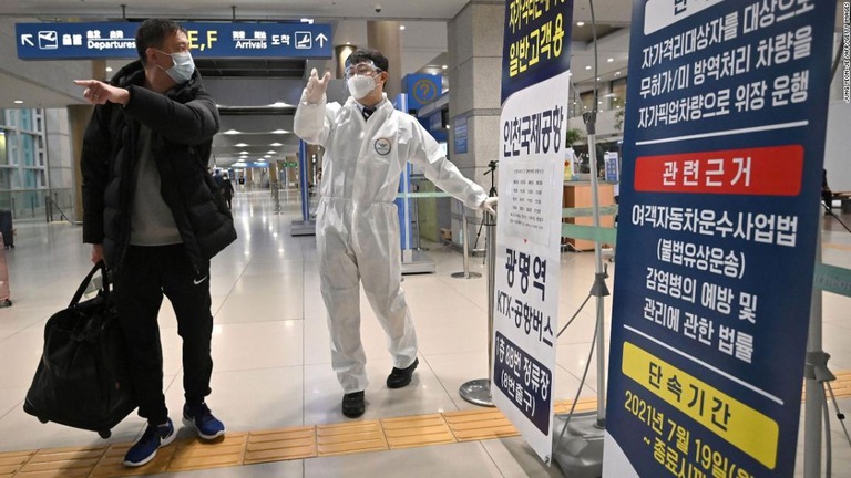 韓国・仁川国際空港で防護具を着用して旅行客を案内する係員/Jung Yeon-je /AFP/Getty Images