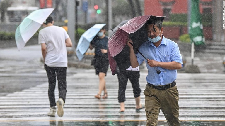 雨の中、傘をさして歩く人々＝７月２５日、中国・寧波市/Hector Retamal/AFP/Getty Images