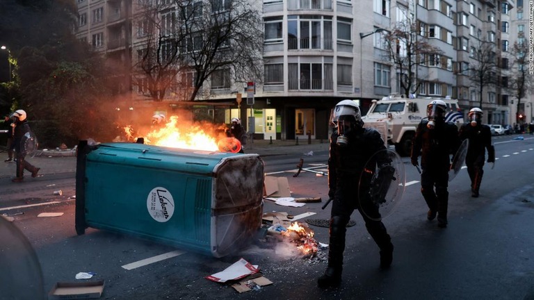 炎の横を歩く機動隊＝５日、ベルギー首都ブリュッセル/Kenzo Tribouillard/AFP/Getty Images