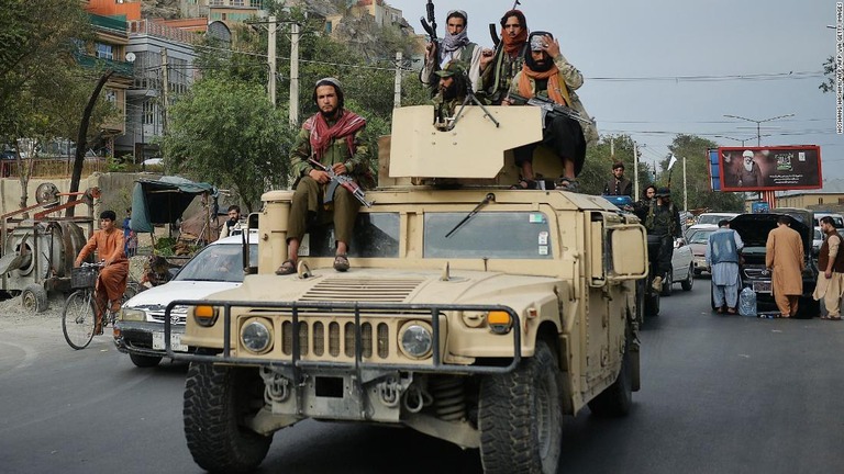軍用車両で街を移動するタリバンの兵士ら/HOSHANG HASHIMI/AFP/AFP via Getty Images