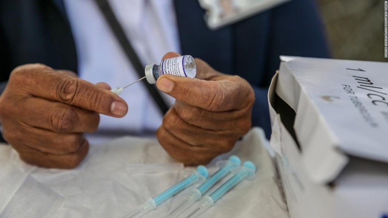 医療従事者が持つ米ファイザー製の新型コロナウイルスワクチン＝南アフリカ・ケープタウン/Dwayne Senior/Bloomberg/Getty Images
