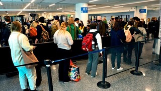 空港の保安検査のため列を作る旅行者＝１６日、米ロサンゼルス