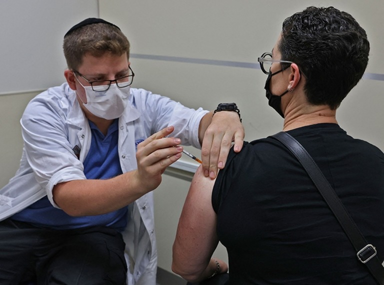 エルサレムの施設でファイザー製ワクチンの３度目の接種を行う医療従事者/Ahmad Gharabli/AFP/Getty Images