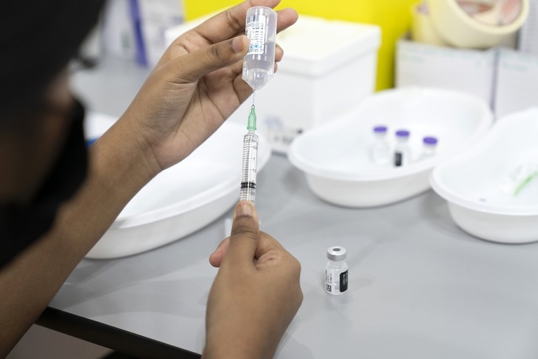 注射器にワクチンを注入する医療従事者＝２０２１年３月、シンガポール/Wei Leng Tay/Bloomberg/Getty Images