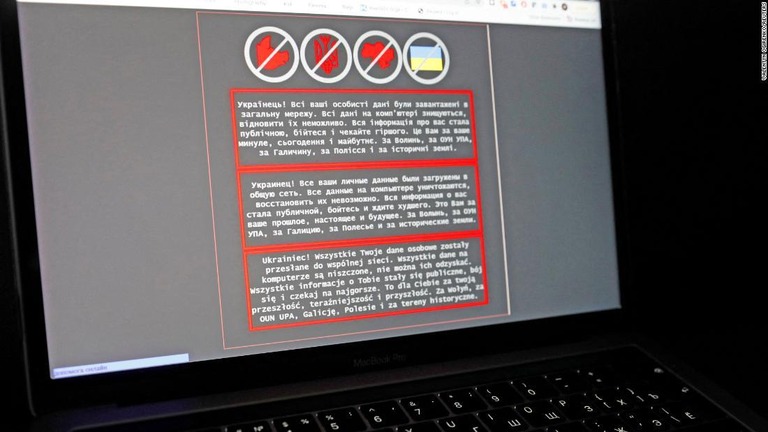 サイバー攻撃により威嚇的な文言が表示されたラップトップパソコンの画面/Valentyn Ogirenko/Reuters