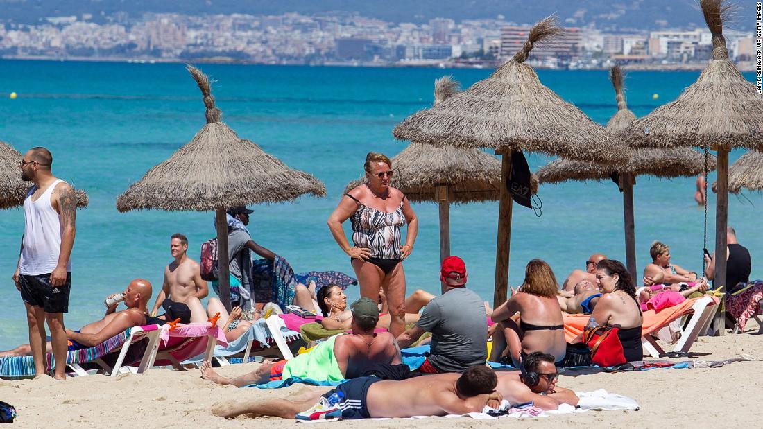 スペインのマジョルカ島にあるパルマビーチを訪れた観光客/JAIME REINA/AFP via Getty Images