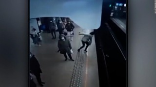女性が男に背後から突き飛ばされて線路上に転落した