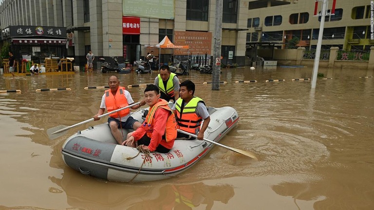 洪水に見舞われた鄭州の街路をゴムボートで移動する救助要員＝２０２１年７月２３日/Noel Celis/AFP/Getty Images