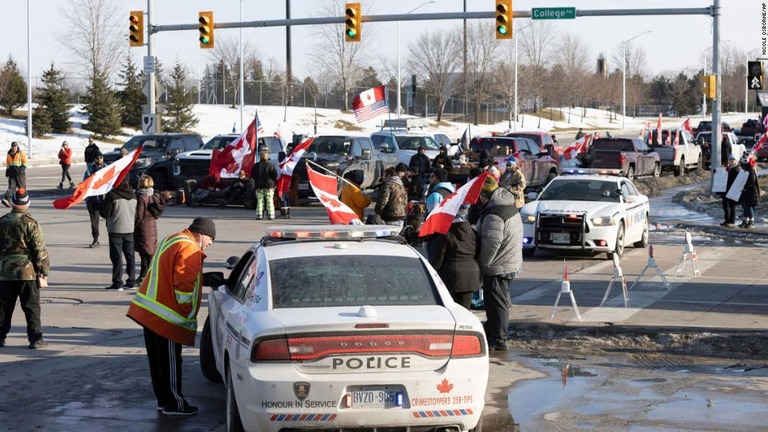 米ミシガン州デトロイトとカナダのオンタリオ州ウィンザーを結ぶアンバサダーブリッジ周辺でデモを行う人々/Nicole Osborne/AP