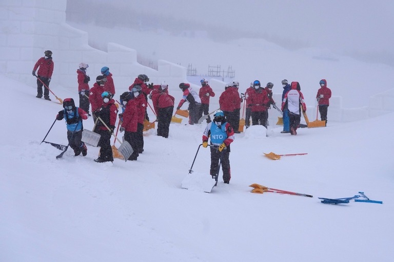 会場の除雪作業を行うボランティア＝１３日/Francisco Seco/AP