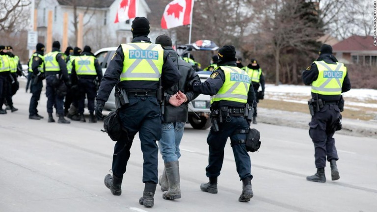 アンバサダーブリッジを封鎖していたデモ参加者を逮捕する警察官ら＝１３日、オンタリオ州ウィンザー/Jeff Kowalsky/AFP/Getty Images