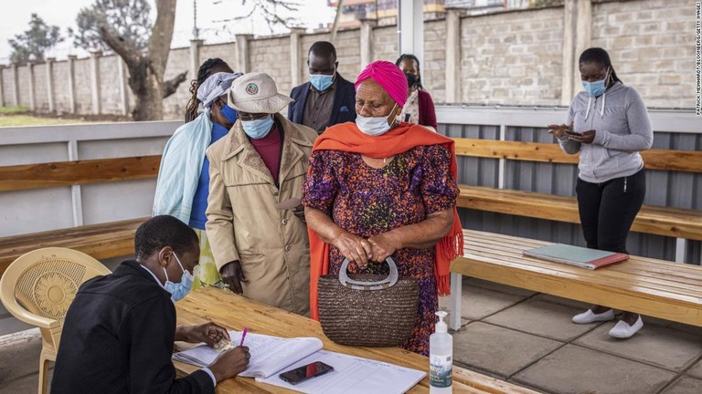 新型コロナウイルスのワクチン接種の受付に並ぶケニア・ナイロビの住民ら＝２１年７月/Patrick Meinhardt/Bloomberg/Getty Images