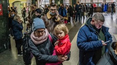キエフの中央駅で切符を買う列に並ぶ人々＝２４日