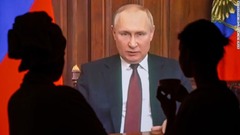 プーチン大統領のテレビ演説を聞くモスクワの人々。プーチン氏はウクライナ東部ドンバス地方での軍事作戦を発表した＝２４日