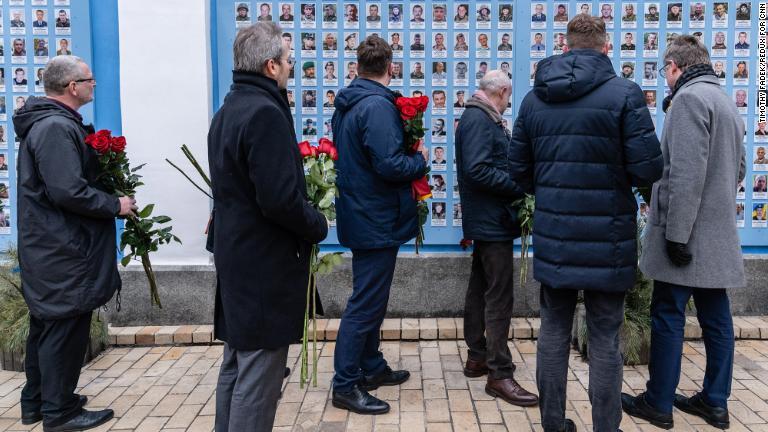 キエフにある追悼の壁にバラの花をささげる欧州各国の大使ら。この壁には２０１４年にロシアが支持する分離独立派との紛争が始まって以降亡くなった軍要員の名前と写真が飾られている＝１６日/Timothy Fadek/Redux for CNN