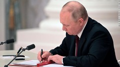 「ドネツク人民共和国」と「ルガンスク人民共和国」を承認する法令に署名するプーチン大統領。同日早く、２地域のトップはプーチン氏に独立と主権の承認を求めていた。プーチン氏の安全保障会議のメンバーはそれに賛成した＝２１日