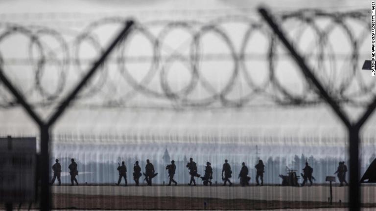 ポーランド南東部ジェシュフヤションカ空港の駐機場を歩く米軍兵士。ロシアとの緊張関係の高まりを受け、空挺部隊はＮＡＴＯの東の境界強化で数千人派遣される部隊の一部となる＝１６日/Wojtek Radawanski/AFP/Getty Images