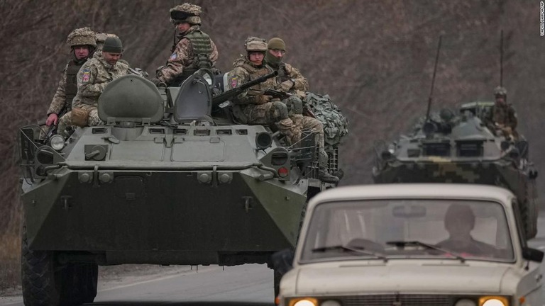 東部ドネツク地方の道路で装甲車の上に乗る兵士＝２４日/Vadim Ghirda/AP