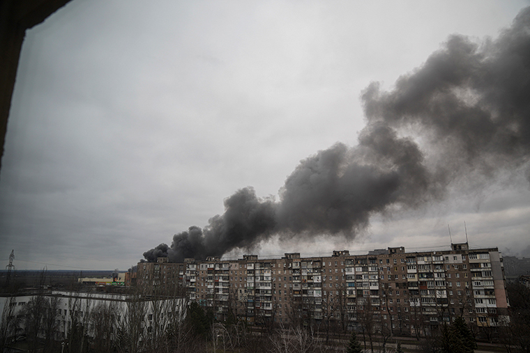 砲撃を受けて煙を上げる建物＝４日、ウクライナ・マリウポリ/Evgeniy Maloletka/AP