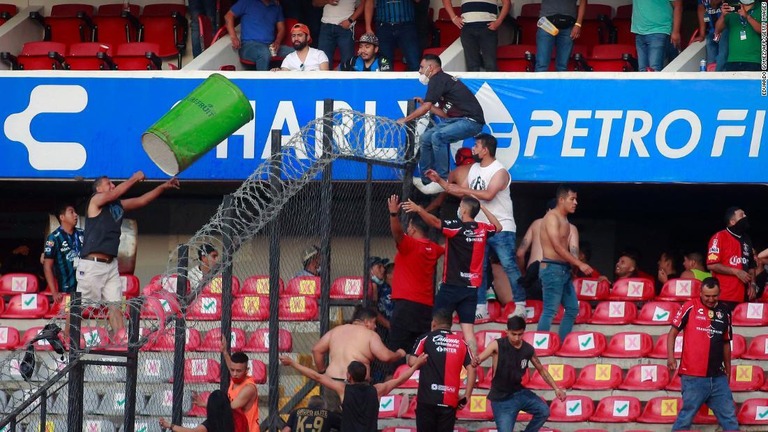 殴り合ったり物を投げたりする観客ら/Eduardo Gomez/AFP/Getty Images