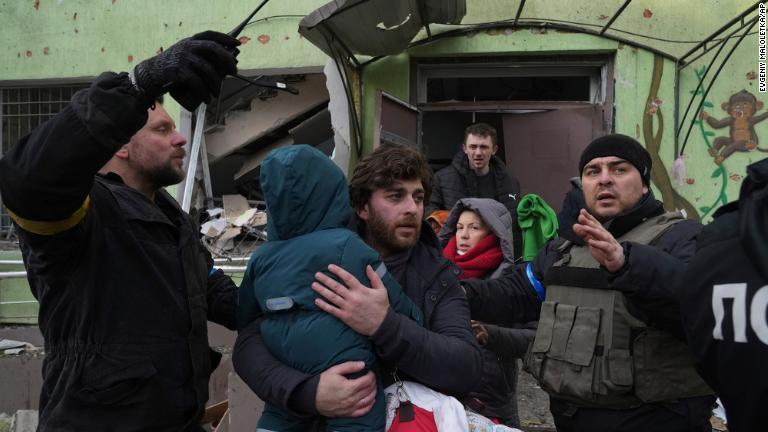 病院から子どもを運び出す男性/Evgeniy Maloletka/AP