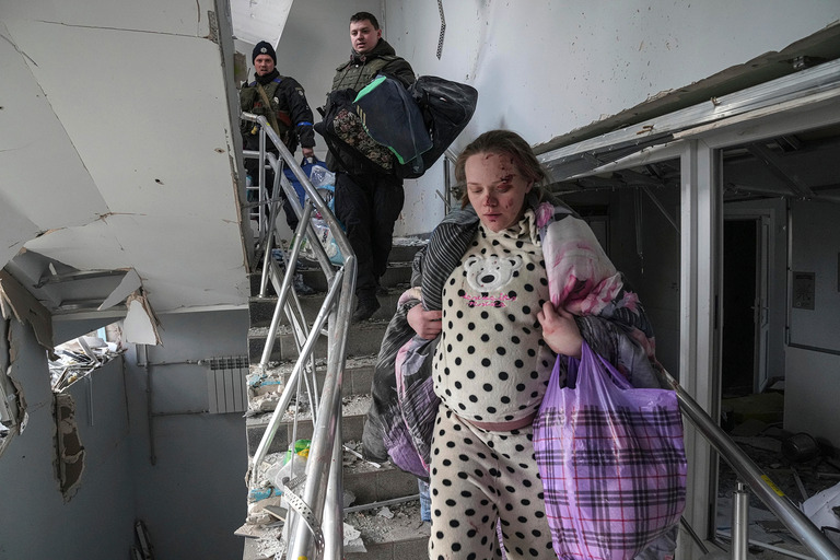爆撃を受けた産科・小児科病院から避難するため階段を降りるビシェギルスカヤさん＝９日、マリウポリ/Evgeniy Maloletka/AP)