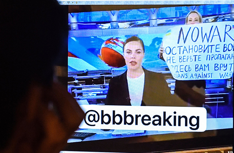ロシア国営テレビ「チャンネル・ワン」のニュース番組に乱入し、戦争反対のメッセージを掲げるマリア・オブシヤニコワ氏を映したコンピューター画面/AFP/Getty Images