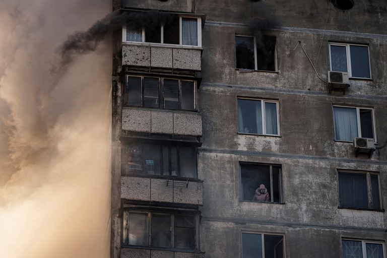 砲撃を受けたキエフの集合住宅で消防隊による救助を待つ人/Felipe Dana/AP