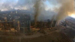 煙が立ち上る住宅＝１４日、ウクライナ・マリウポリ