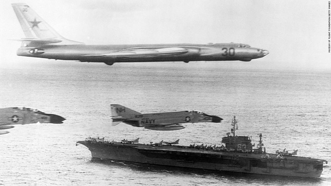ロシア製のツポレフTu16「バジャー」偵察爆撃機1機が米海軍の護衛戦闘機とともに空母キティホークの上空を飛行する。冷戦期の北太平洋での活動中=1963年1月/Museum of Flight Foundation/Getty Images