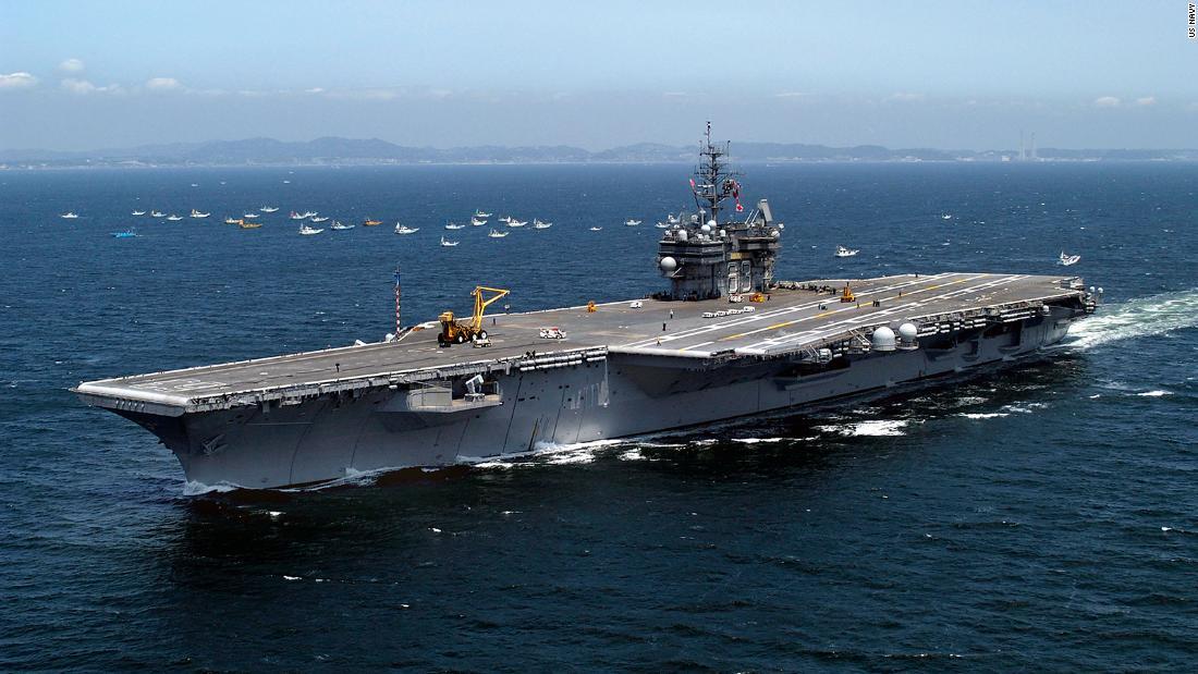 横須賀基地を出港して相模湾へ向かうキティホーク。奥に日本の漁船団が見える=2005年5月17日/US Navy