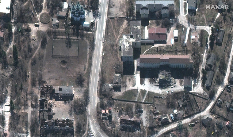 市中心部に空いた穴。その片側には校舎の焼け跡、もう片側にはサッカー場が見える/Maxar Technologies