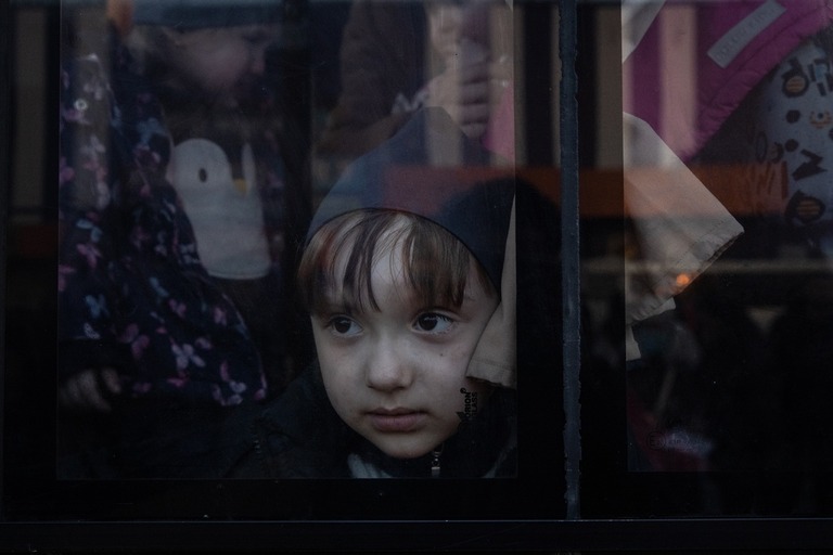 バスの中から外を見つめる子ども。マリウポリやメリトポリから避難する数百人を乗せたバスが避難地点に到着＝２５日、ザポリージャ/Chris McGrath/Getty Images